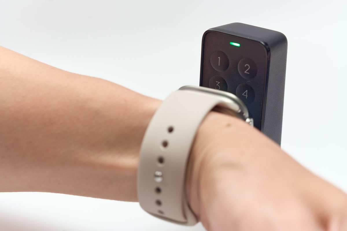 指紋認証パッドに実際に腕につけたApple Watchを近づけている