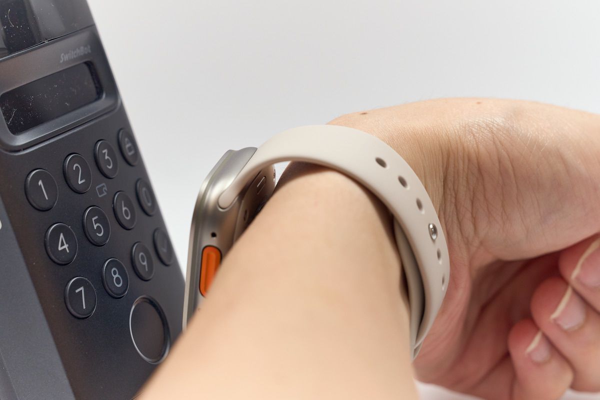 SwitchBot顔認証パッドにApple Watchを近づけている