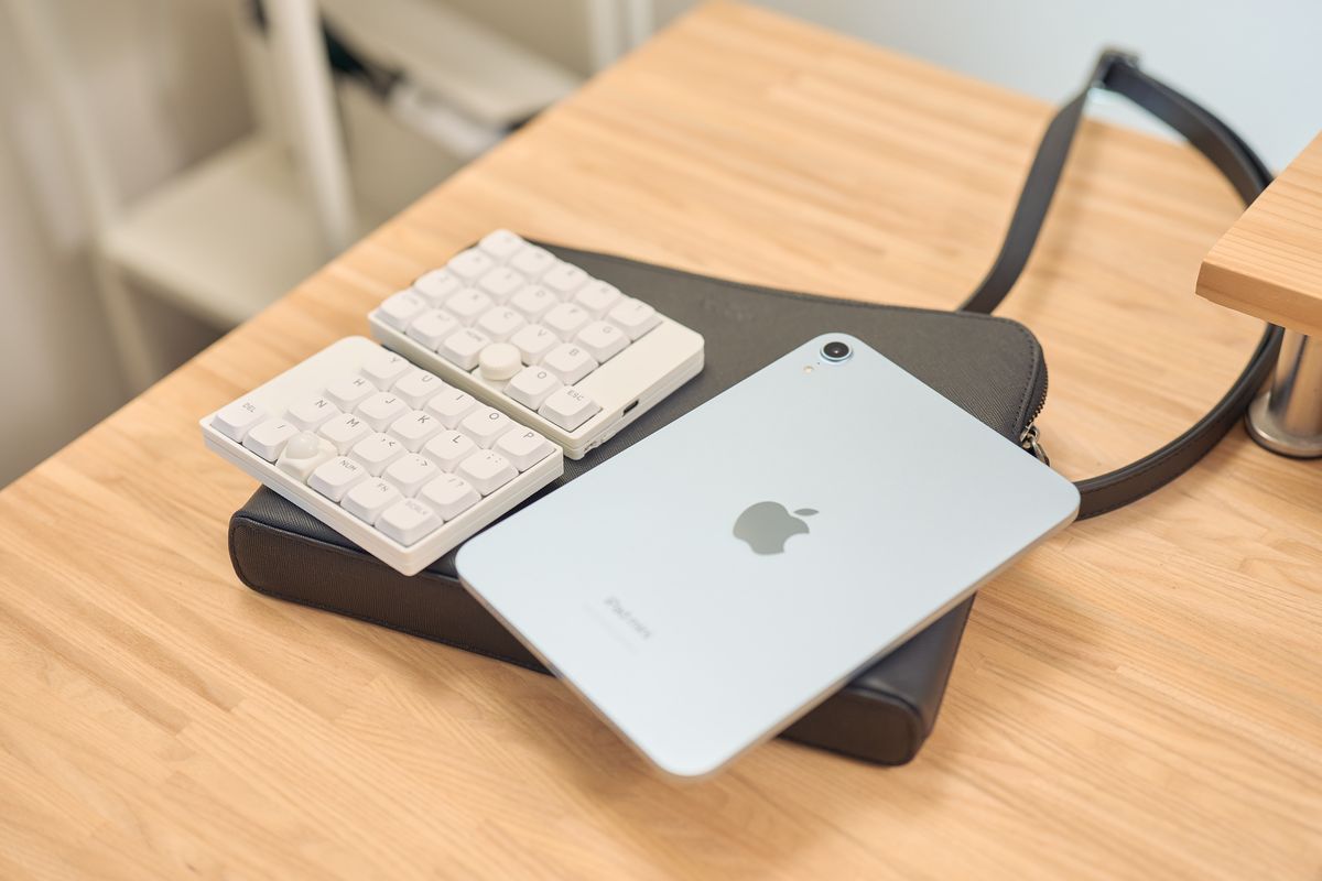 Evoon みがるサコッシュレザーの上にiPad miniと分割キーボードを置いている