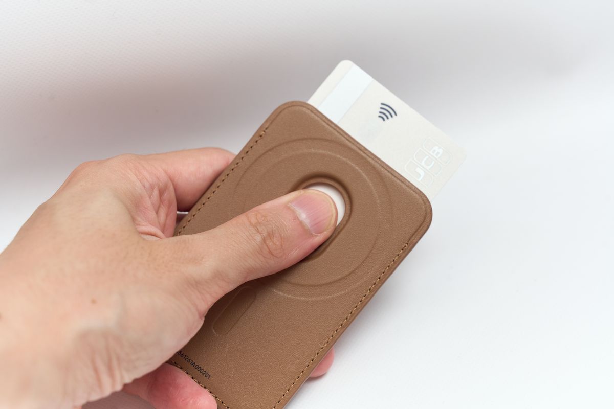 マグネット式編み込みウォレットに入れたカードを片手で取り出している