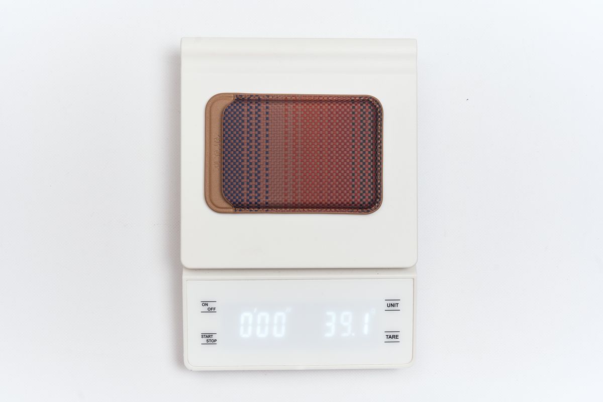 マグネット式編み込みウォレットの重さを量っている