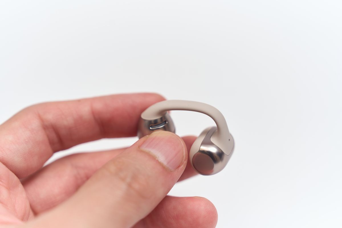 Shokz OpenDots ONEのイヤホンを手に持っている