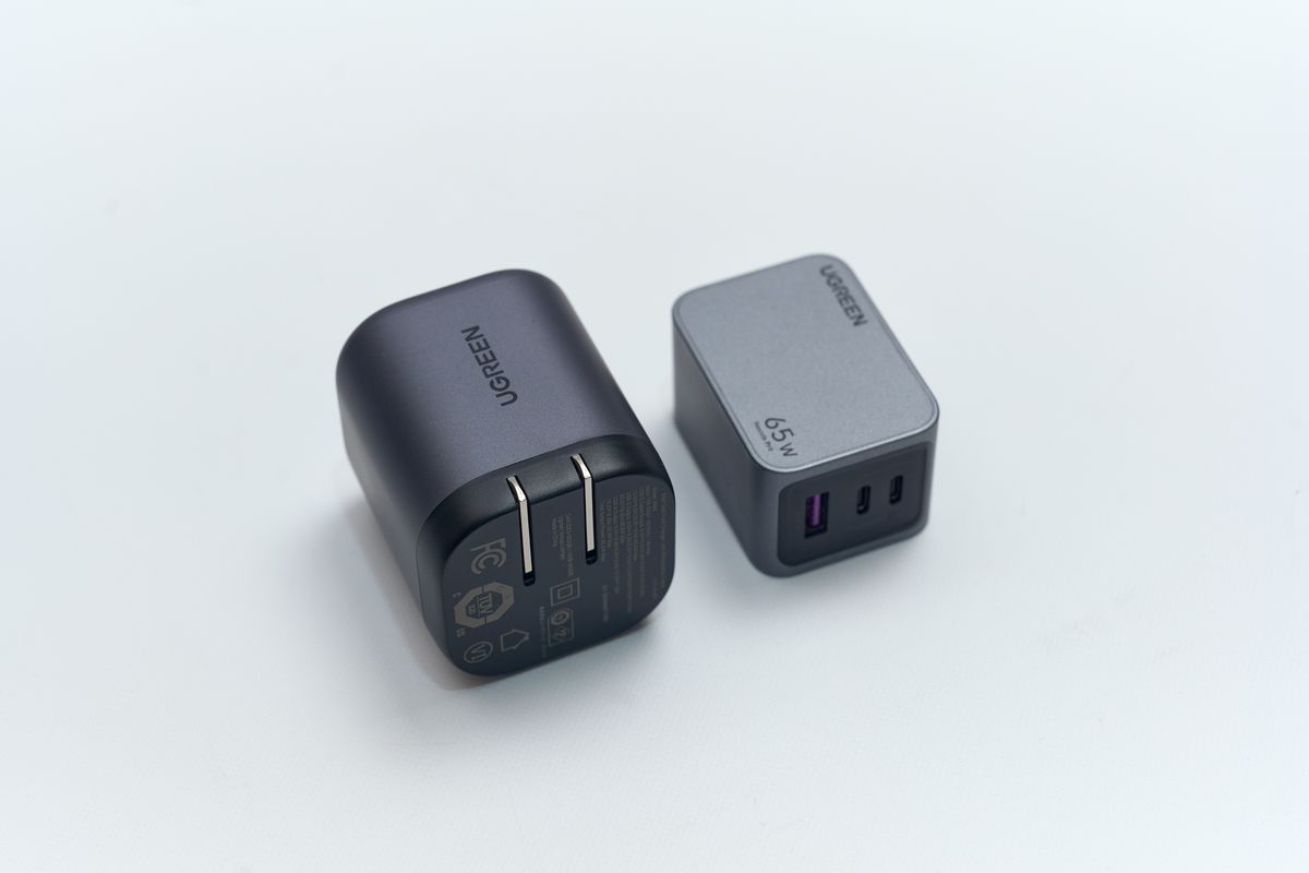 UGREEN Nexode 巻き取り式 USB-Cケーブル内蔵 充電器 65Wと同メーカーの65W充電器を並べて厚みを比較している