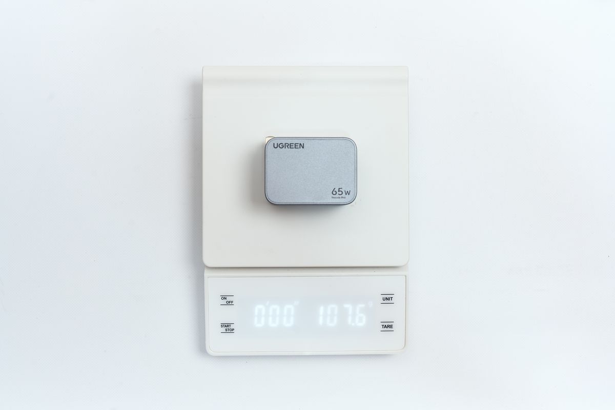 UGREENの65W充電器の重さを量っている