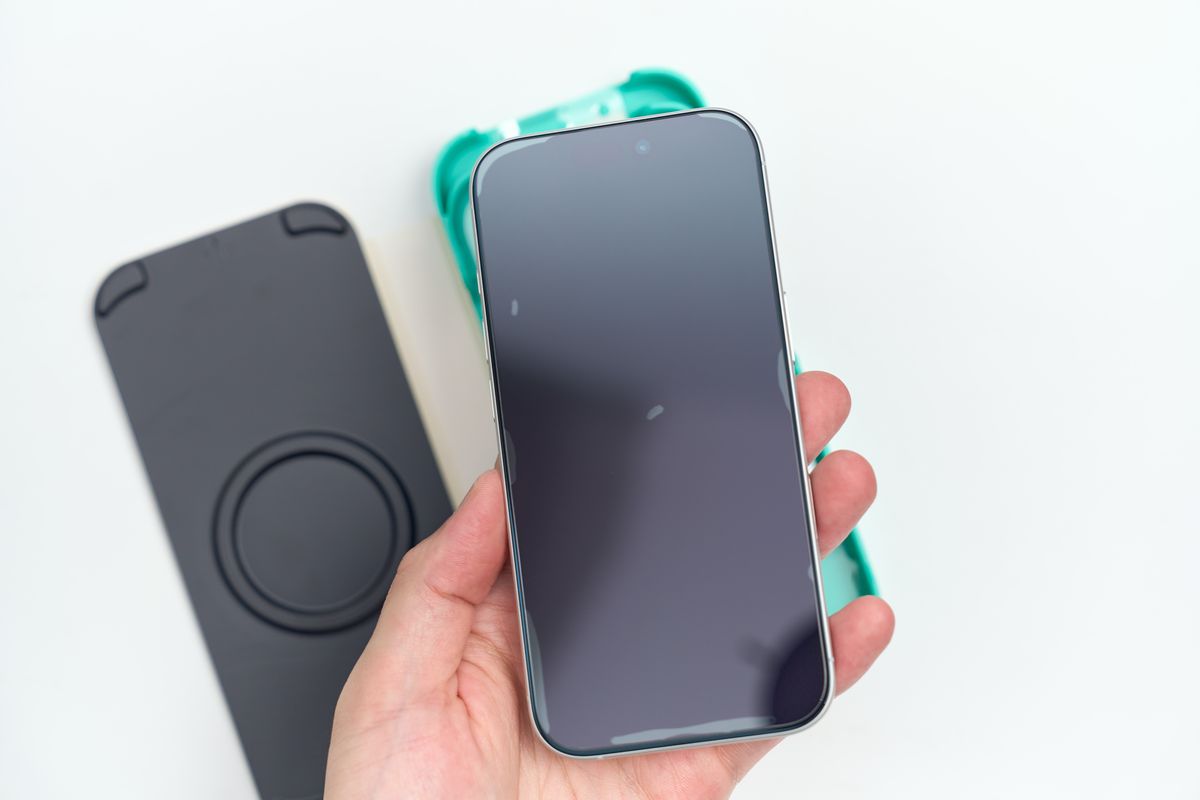 フィルムを張ったiPhone 17を手に持っている