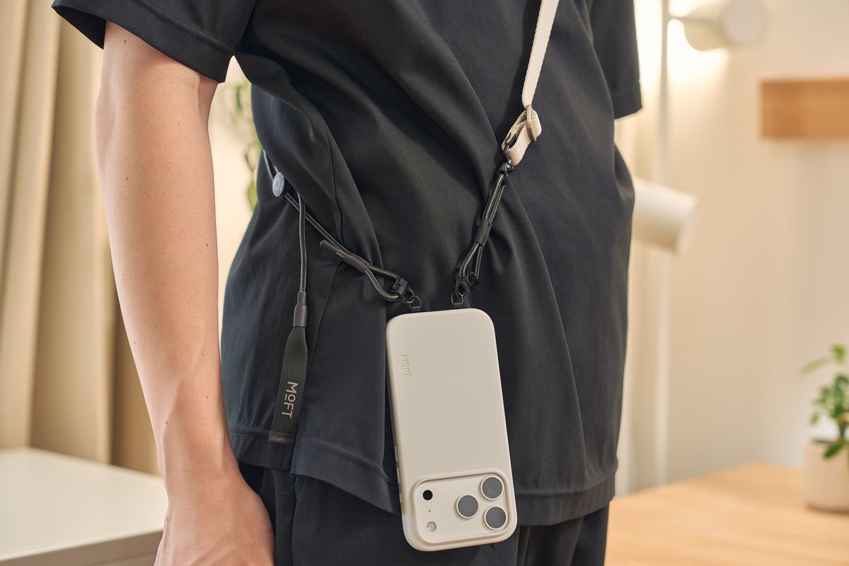 全機種対応スリングストラップ アップグレード版をつけたiPhoneを肩に下げている